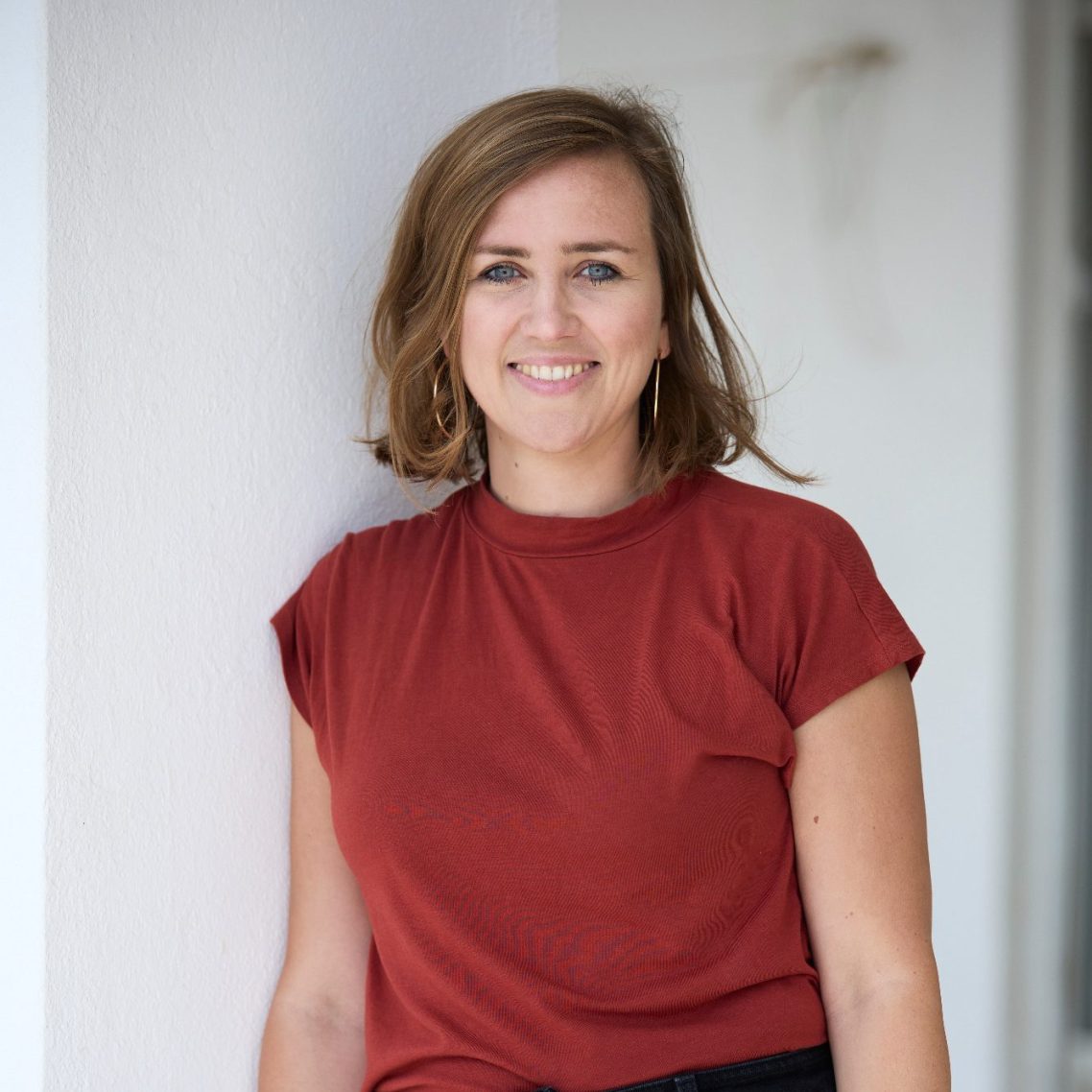 Portrait der Website-Betreiberin vor einer weißen Mauer